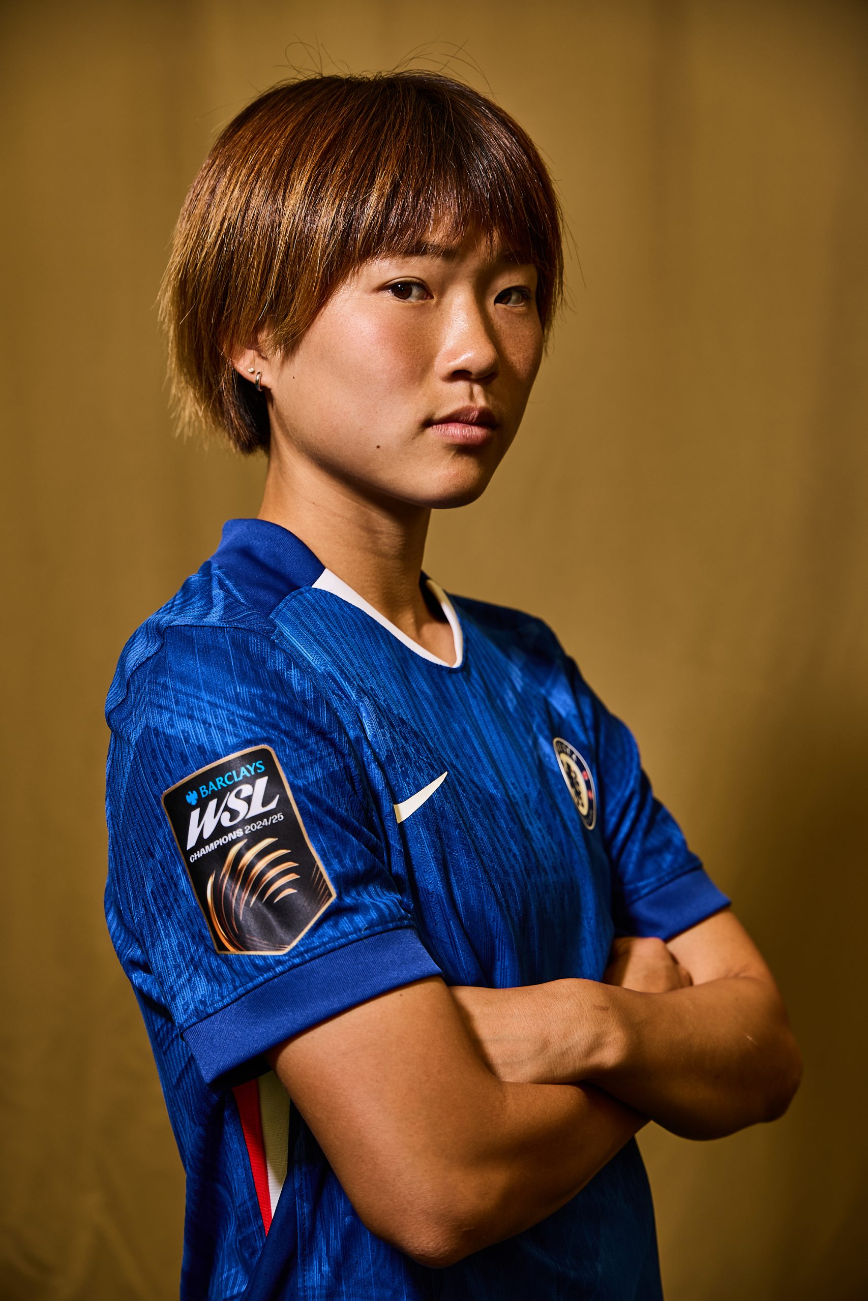 An image showing a Chelsea Women FC player wearing a digital satin WSL winners badge